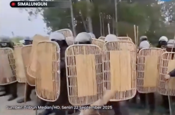 Para penyerang menggunakan tameng