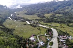foto drone lembah dengan sungai dan kampung kecil