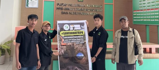 empat orang dengan spanduk besar #SaveRawaTripa di gedung Dinas Kehutanan Aceh