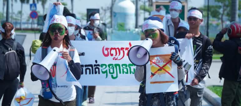 Lantang dan jelas : Anggota MNC protes menentang perusakan alam Sebuah kelompok mahasiswa berjalan dengan megafon dan spanduk melewati sebuah jalan
