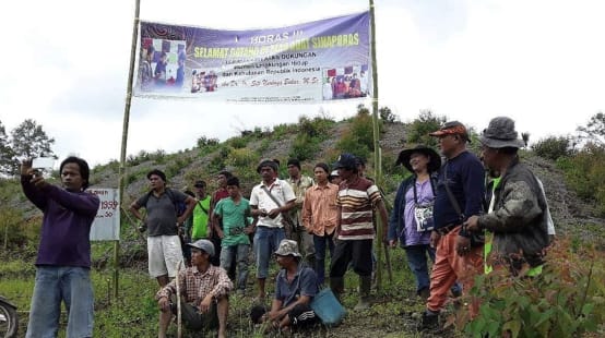 Kelompok petani dengan tranparan diatas bukit