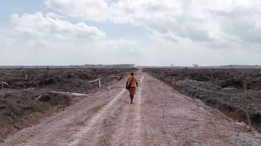 seorang laki-laki berjalan di lahan gundul