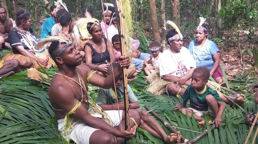 kelompok masyarakat Wambon duduk diatas daun kelapa