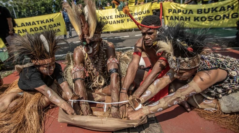 4 warga Papua dengan hiasan bulu burung di kepala sedang melakukan ritual. „Papua bukanlah tanah kosong“